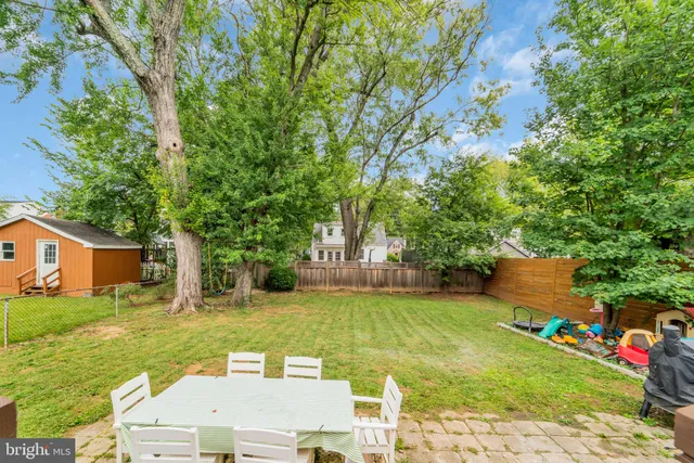 a view of a house with a big yard and large trees