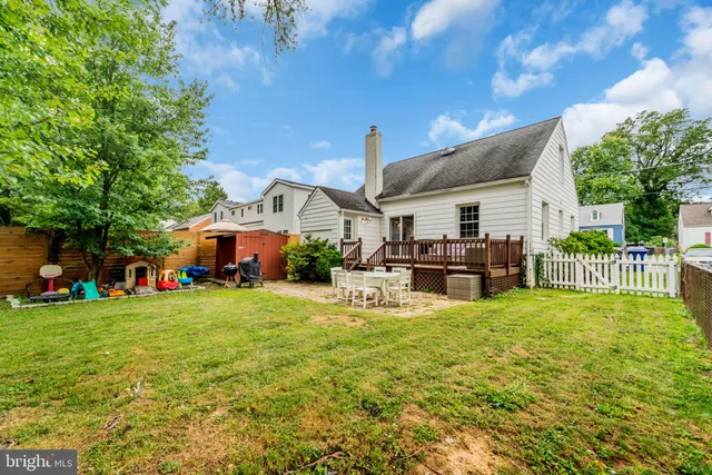 a view of a patio with table and chairs potted plants and a large tree
