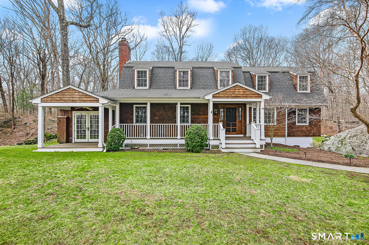 99 Chicken Street Wilton, CT 06897 - Photo 1 of 38 a front view of a house with a yard table and chairs