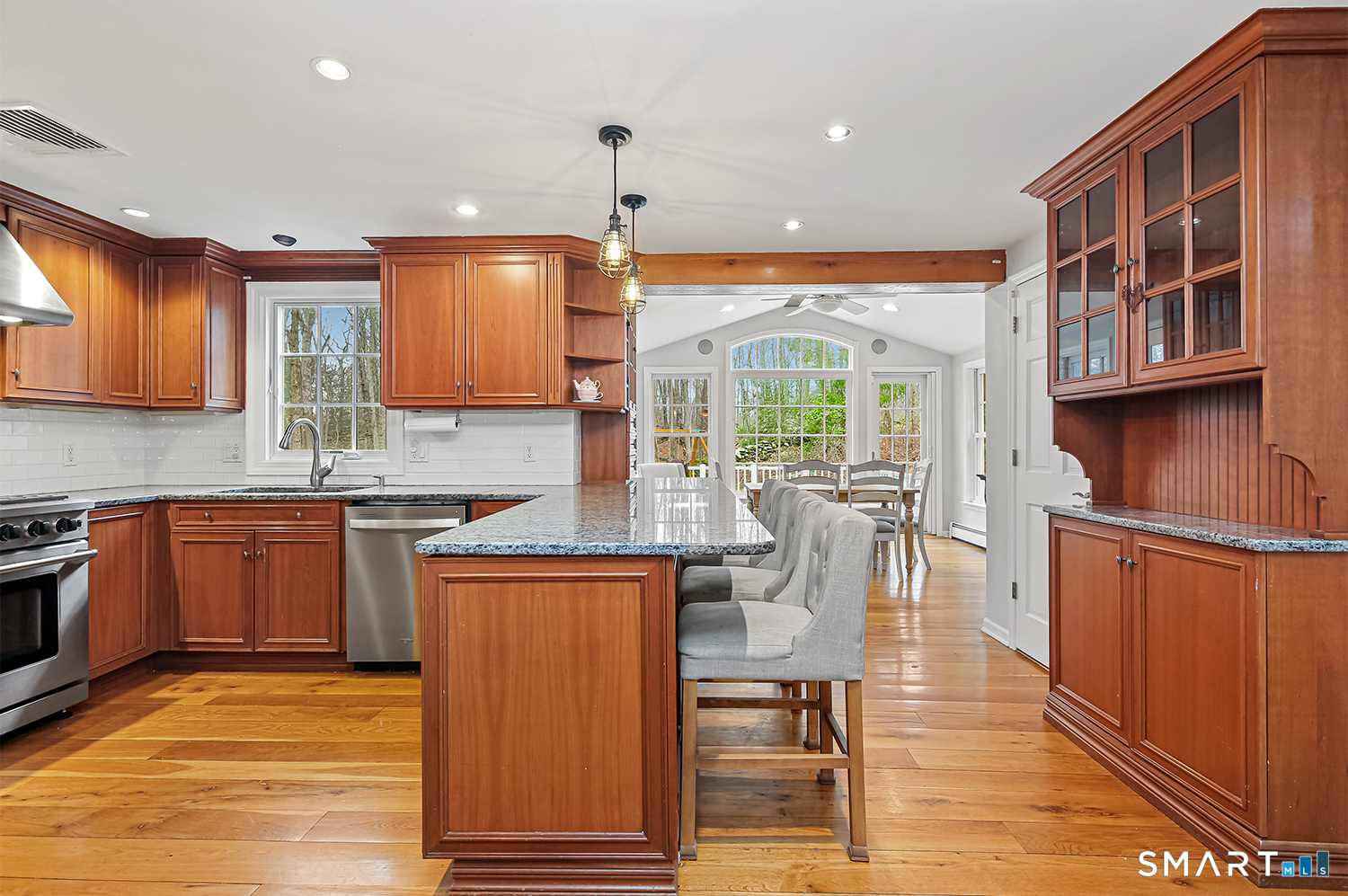 99 Chicken Street Wilton, CT 06897 - Photo 5 of 38 a kitchen with stainless steel appliances granite countertop a refrigerator a sink dishwasher a stove and a dining table with wooden floor