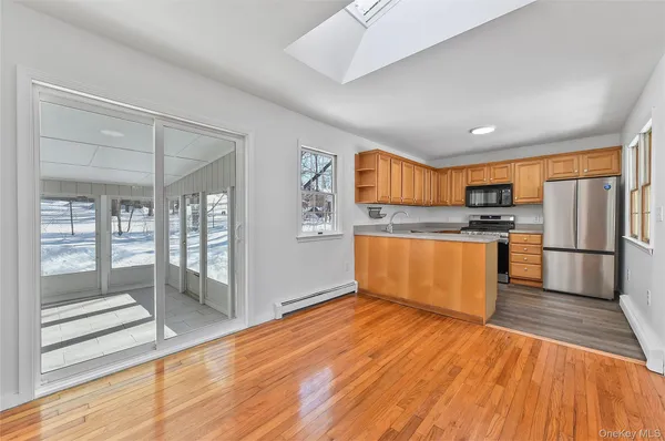 a kitchen with stainless steel appliances granite countertop a sink a stove and a refrigerator with wooden floor