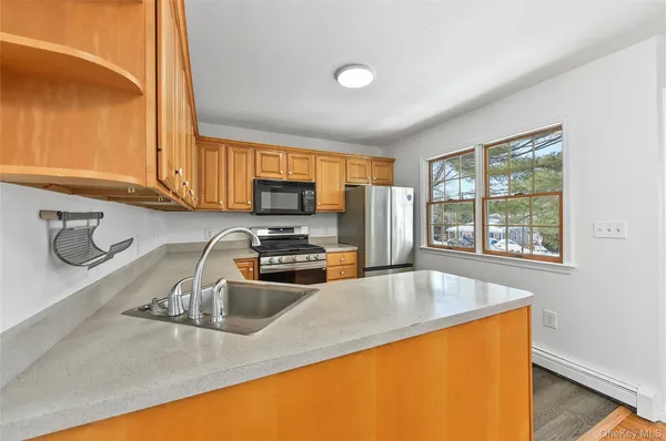 a kitchen with stainless steel appliances granite countertop a refrigerator stove microwave sink and cabinets