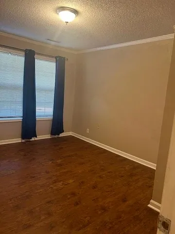 an empty room with wooden floor and chandelier fan
