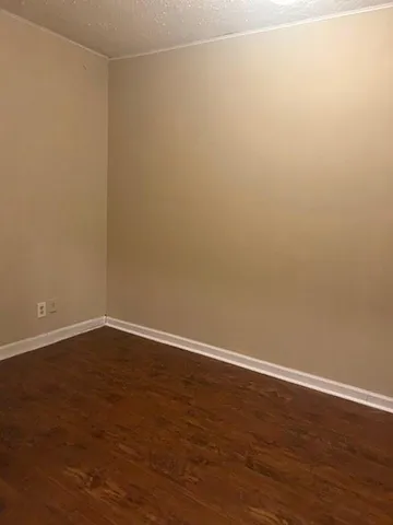 en empty room with wooden floor and windows