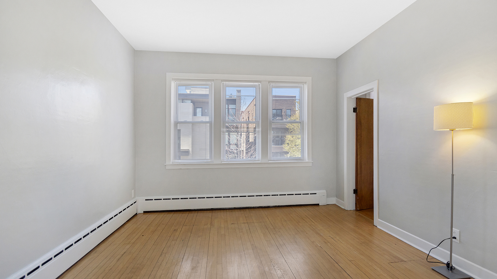 2905 North Burling Street, Unit 2 Chicago, IL 60657 - Photo 2 of 17 an empty room with wooden floor and windows