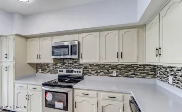 a kitchen with granite countertop a stove sink and cabinets