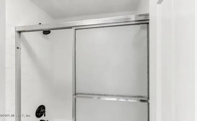 a bathroom with a glass shower door