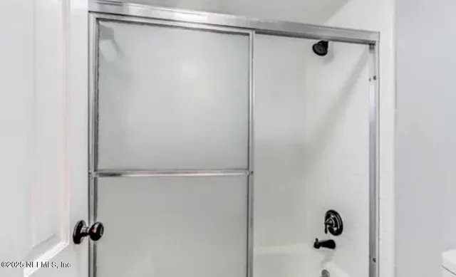 a bathroom with a glass shower door