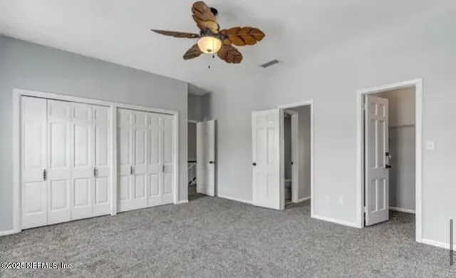 a view of an empty room and chandelier fan