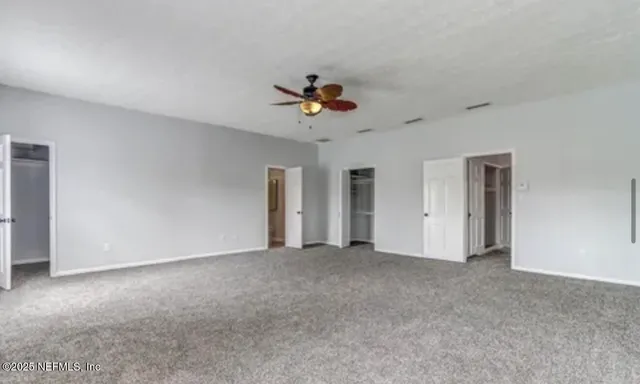 a view of an empty room with a ceiling fan