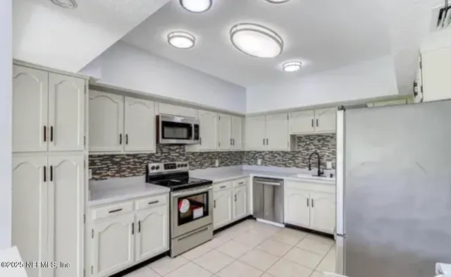 a kitchen with a sink cabinets and stainless steel appliances