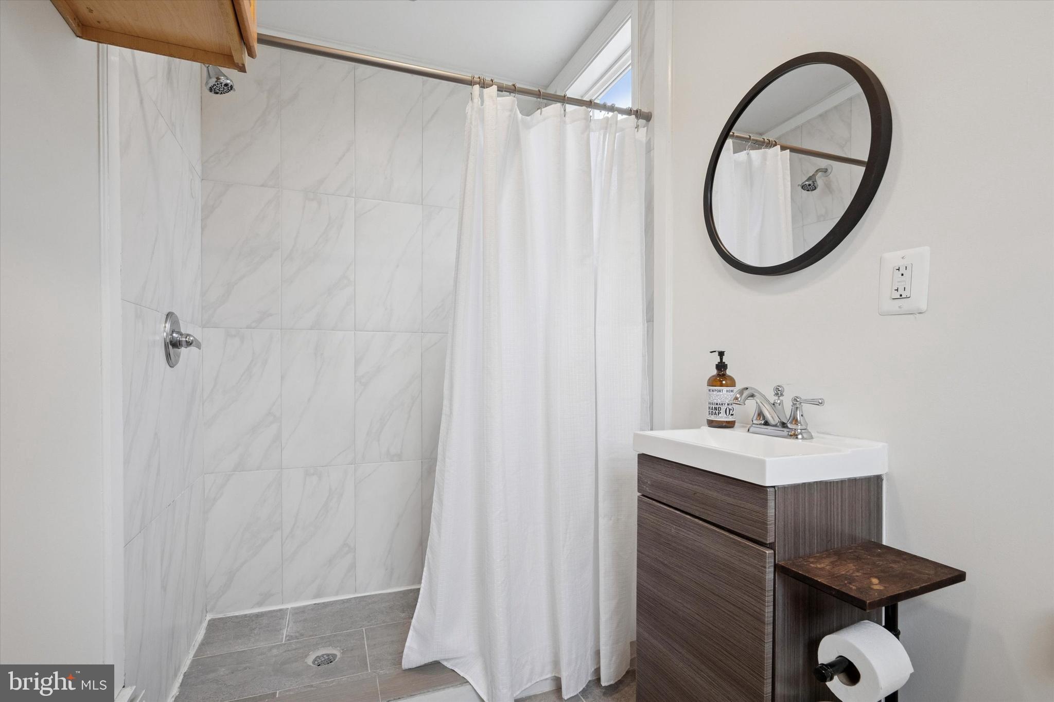 228 Avon Road Narberth, PA 19072 - Photo 14 of 24 a bathroom with a sink a mirror and a shower curtain