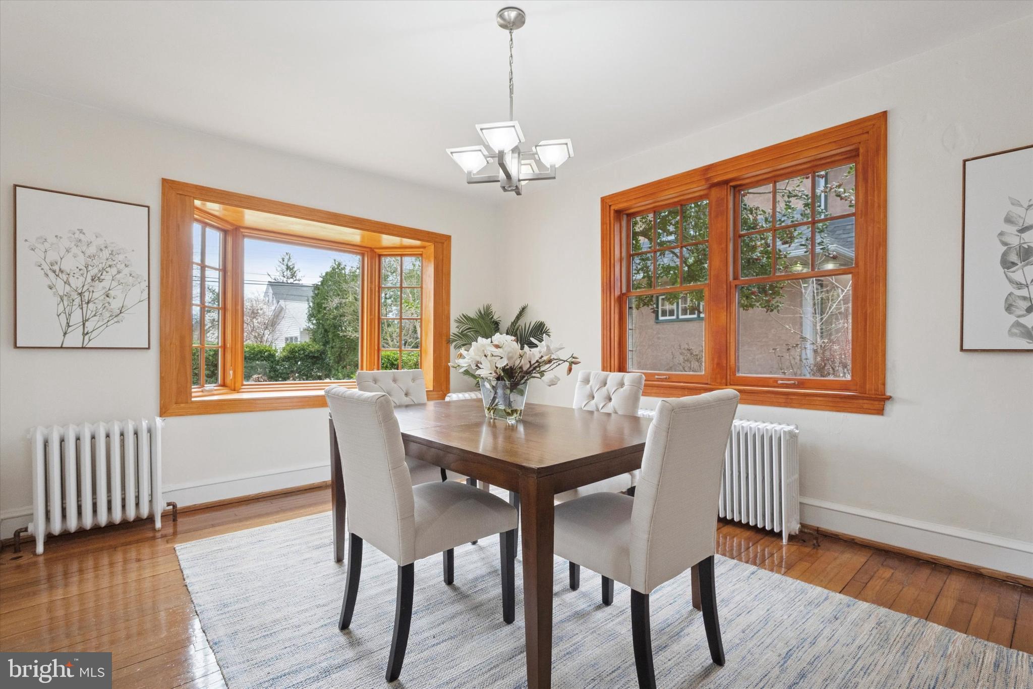 228 Avon Road Narberth, PA 19072 - Photo 10 of 24 a dining room with wooden floor a chandelier a wooden table and chairs