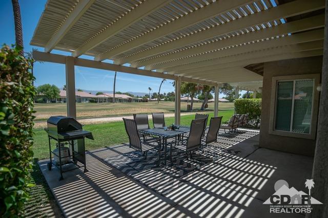 82320 Lancaster Way Indio, CA 92201 - Photo 1 of 27 a view of a patio with table and chairs barbeque potted plants and large tree