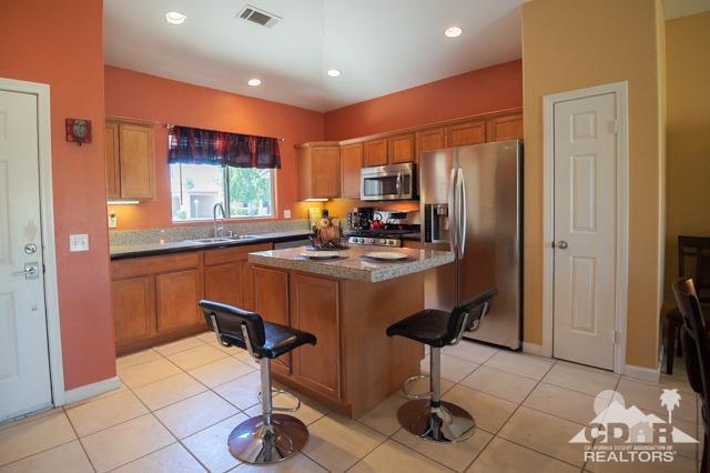 82320 Lancaster Way Indio, CA 92201 - Photo 2 of 27 a kitchen with stainless steel appliances a stove top oven cabinets a refrigerator and a sink