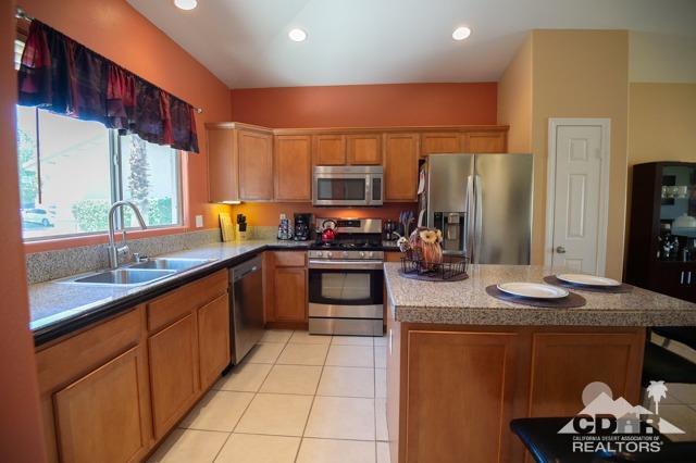 82320 Lancaster Way Indio, CA 92201 - Photo 3 of 27 a kitchen with stainless steel appliances granite countertop a sink stove and refrigerator