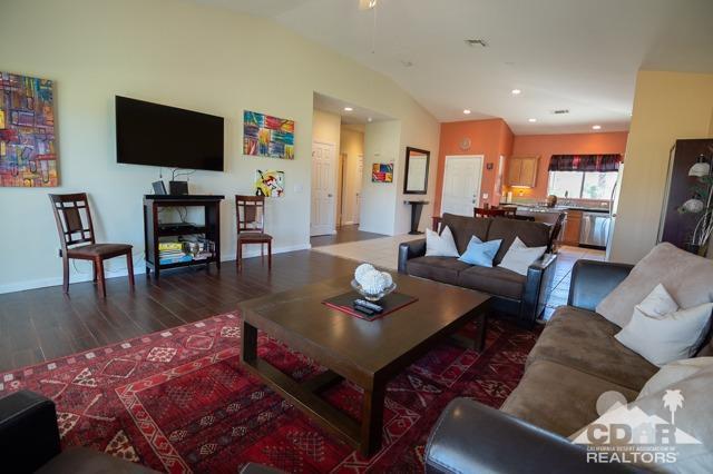 82320 Lancaster Way Indio, CA 92201 - Photo 6 of 27 a living room with furniture and a flat screen tv with kitchen view