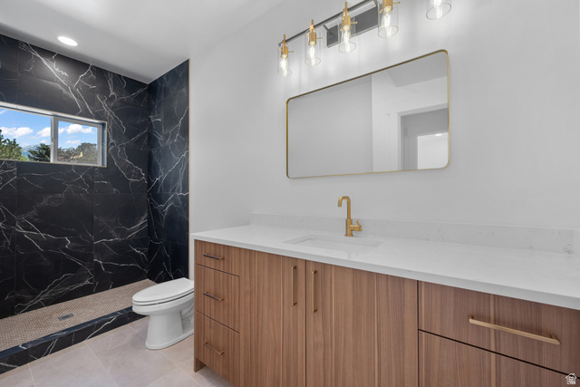 7238 South 525 East Midvale, UT 84047 - Photo 17 of 29 Modern bathroom featuring a wood-finish vanity with a white countertop and gold-tone fixtures