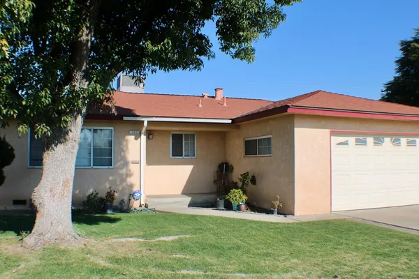 a front view of a house with a garden and yard