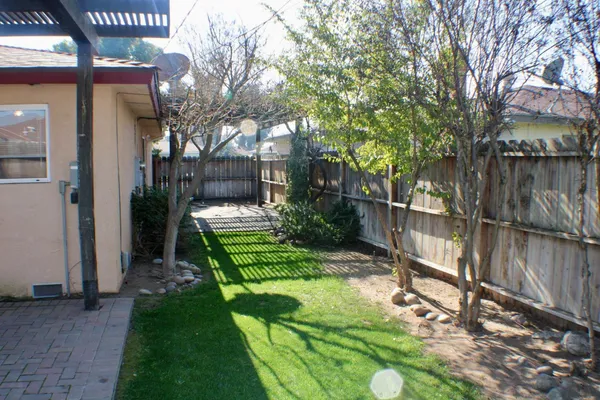 a view of a house with backyard and sitting area