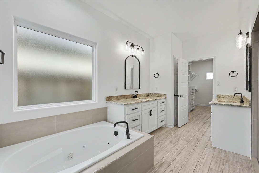 143 Amethyst Street Portland, TX 78374 - Photo 11 of 26 a spacious bathroom with a granite countertop sink mirror and bathtub