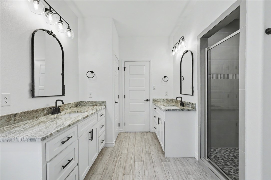 143 Amethyst Street Portland, TX 78374 - Photo 12 of 26 a spacious bathroom with a granite countertop sink a mirror and shower