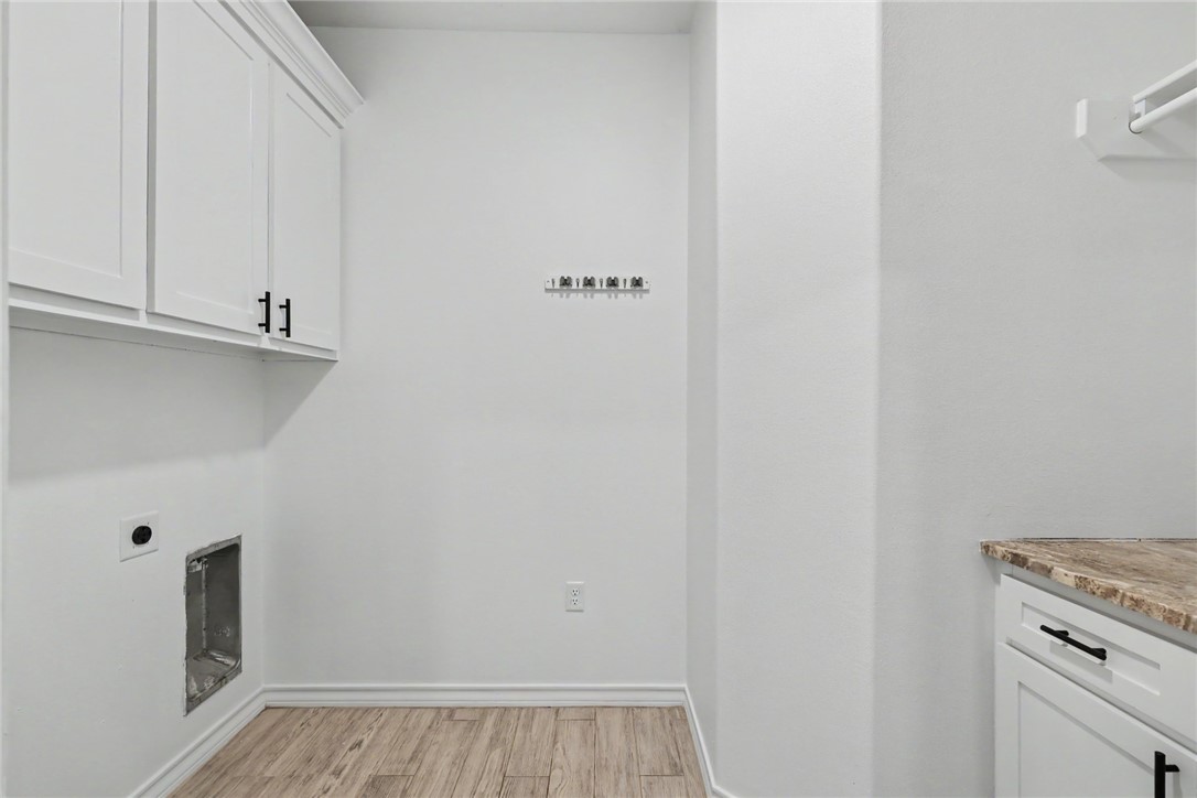 143 Amethyst Street Portland, TX 78374 - Photo 16 of 26 a view of a kitchen with white cabinets and a stove