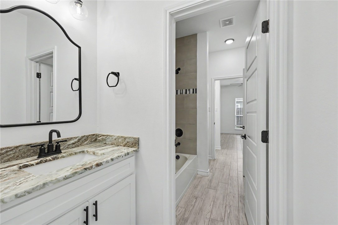 143 Amethyst Street Portland, TX 78374 - Photo 19 of 26 a bathroom with a granite countertop sink mirror and shower
