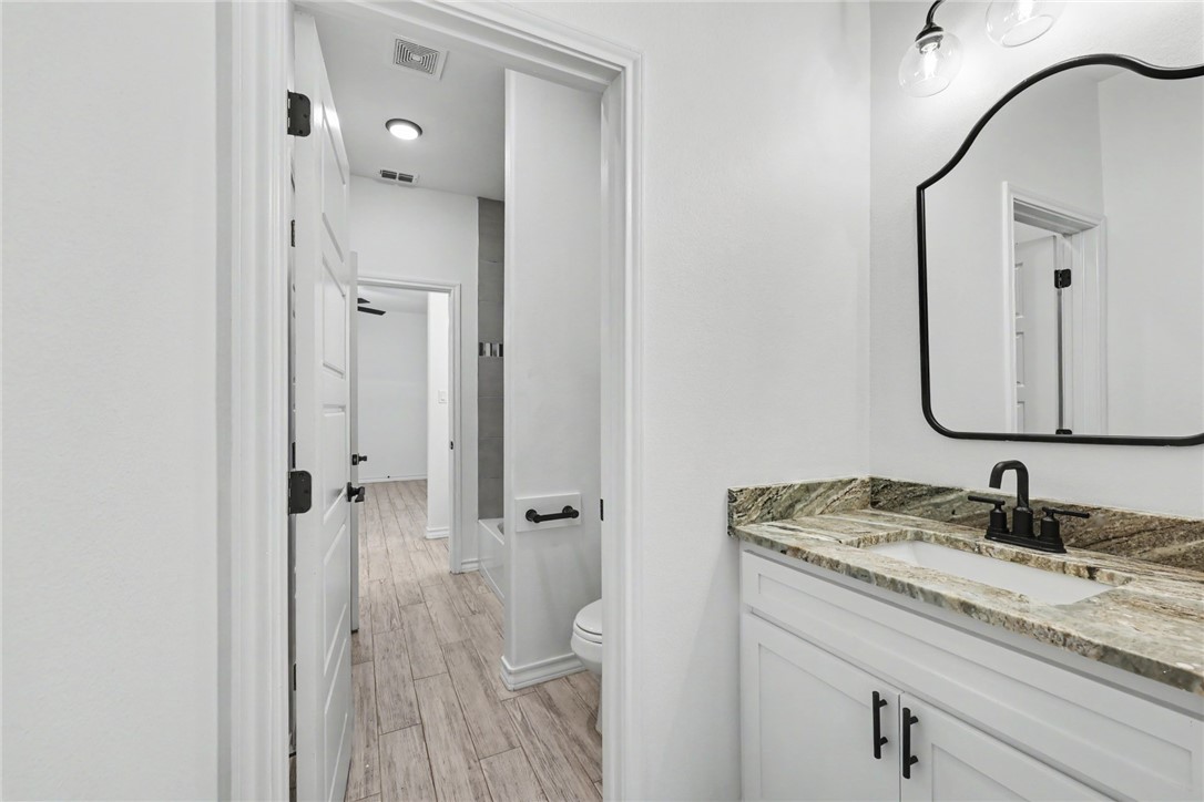 143 Amethyst Street Portland, TX 78374 - Photo 20 of 26 a bathroom with a granite countertop sink vanity mirror and a