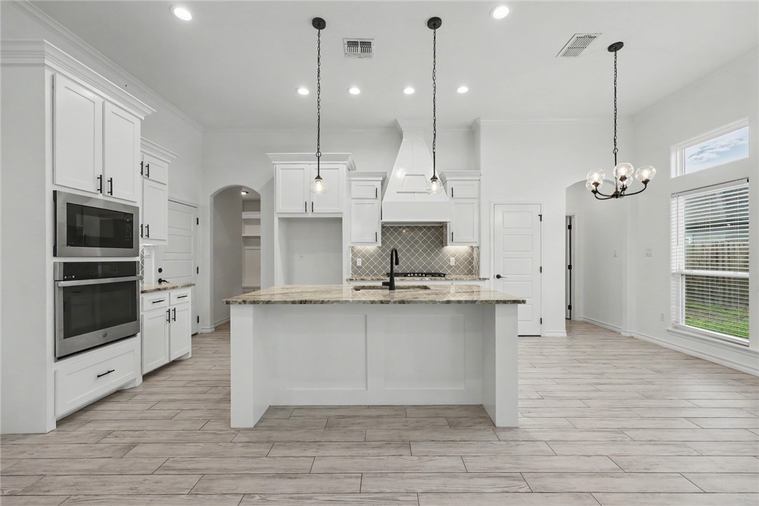 143 Amethyst Street Portland, TX 78374 - Photo 24 of 26 a large kitchen with stainless steel appliances kitchen island granite countertop a large island in the center