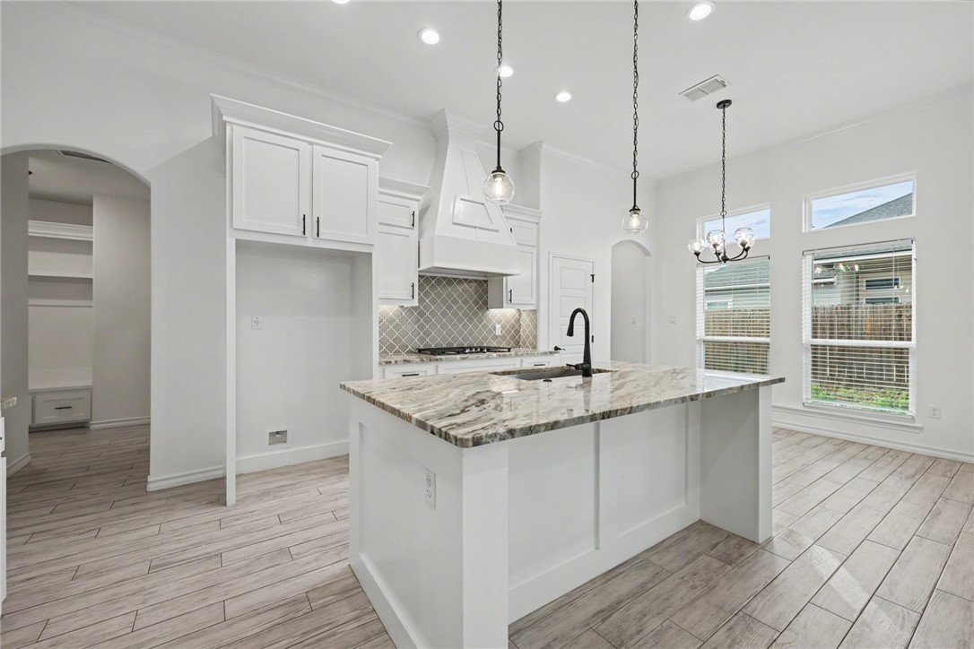 143 Amethyst Street Portland, TX 78374 - Photo 25 of 26 a kitchen with stainless steel appliances granite countertop a sink a oven a refrigerator with grey cabinets and wooden floor