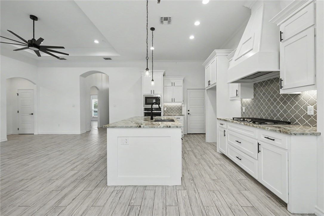 143 Amethyst Street Portland, TX 78374 - Photo 26 of 26 a large kitchen with cabinets wooden floor and stainless steel appliances
