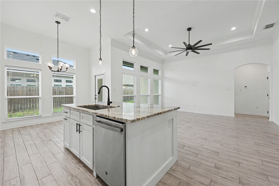143 Amethyst Street Portland, TX 78374 - Photo 4 of 26 a kitchen with stainless steel appliances granite countertop a sink a stove and a wooden floors