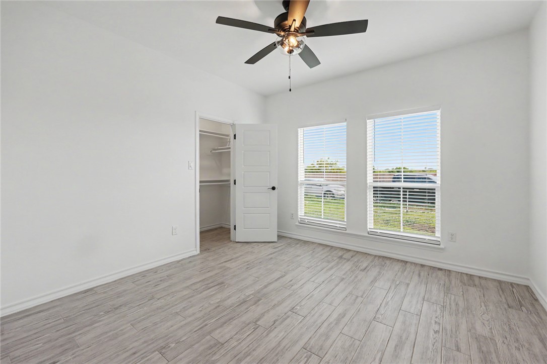 143 Amethyst Street Portland, TX 78374 - Photo 7 of 26 wooden floor in an empty room with a window