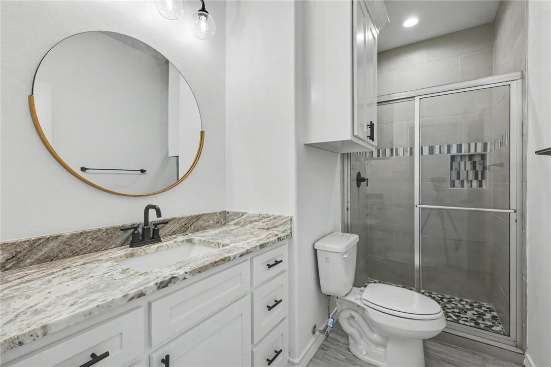 143 Amethyst Street Portland, TX 78374 - Photo 8 of 26 a bathroom with a granite countertop sink toilet and a mirror