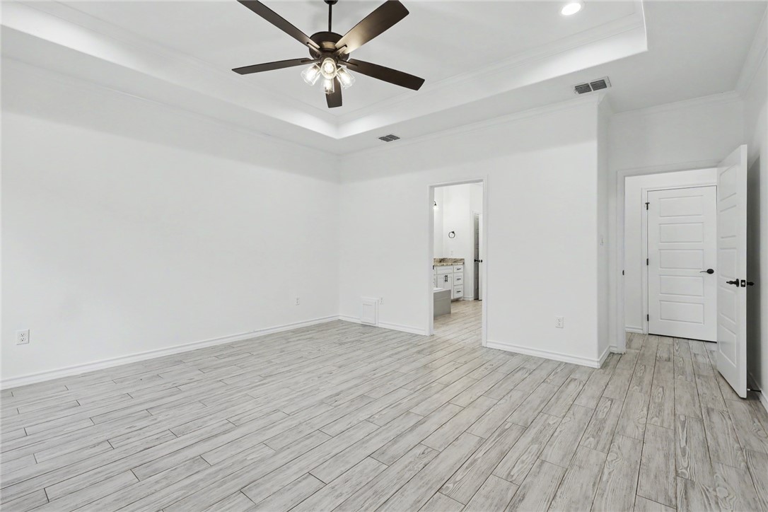 143 Amethyst Street Portland, TX 78374 - Photo 10 of 26 an empty room with wooden floor and a ceiling fan