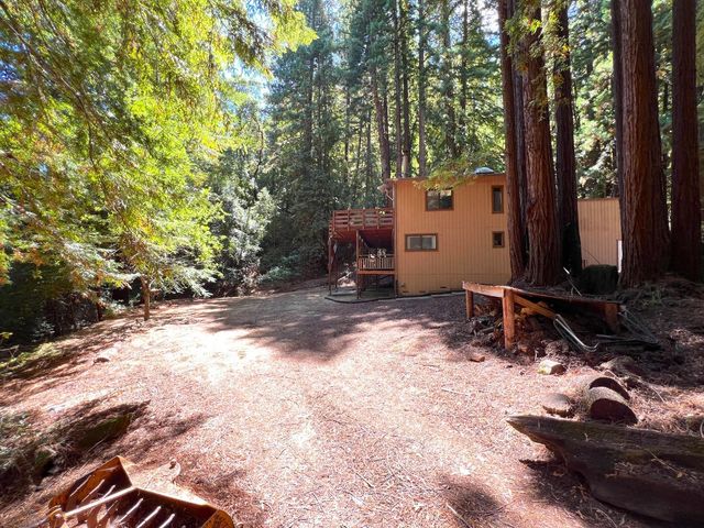 a backyard of a house with barbeque oven and trees