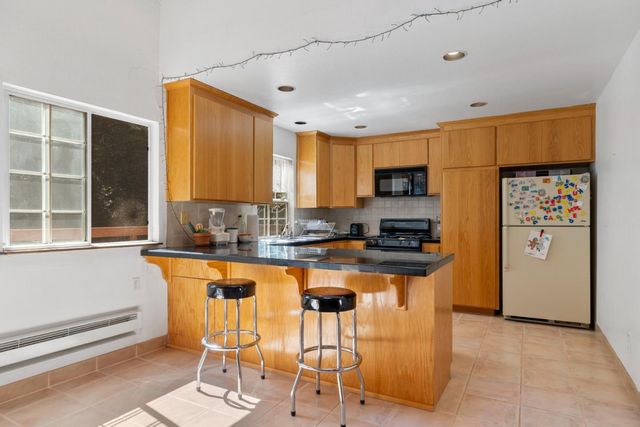 a kitchen with stainless steel appliances granite countertop a stove a refrigerator a kitchen island a stove and a refrigerator