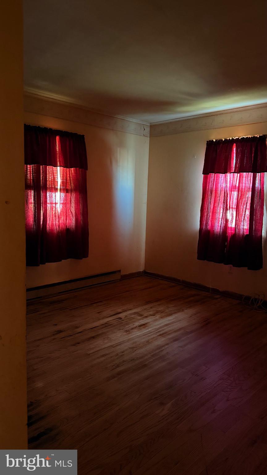 711 Rigby Avenue Cambridge, MD 21613 - Photo 19 of 21 Sunlit room with vibrant red curtains.