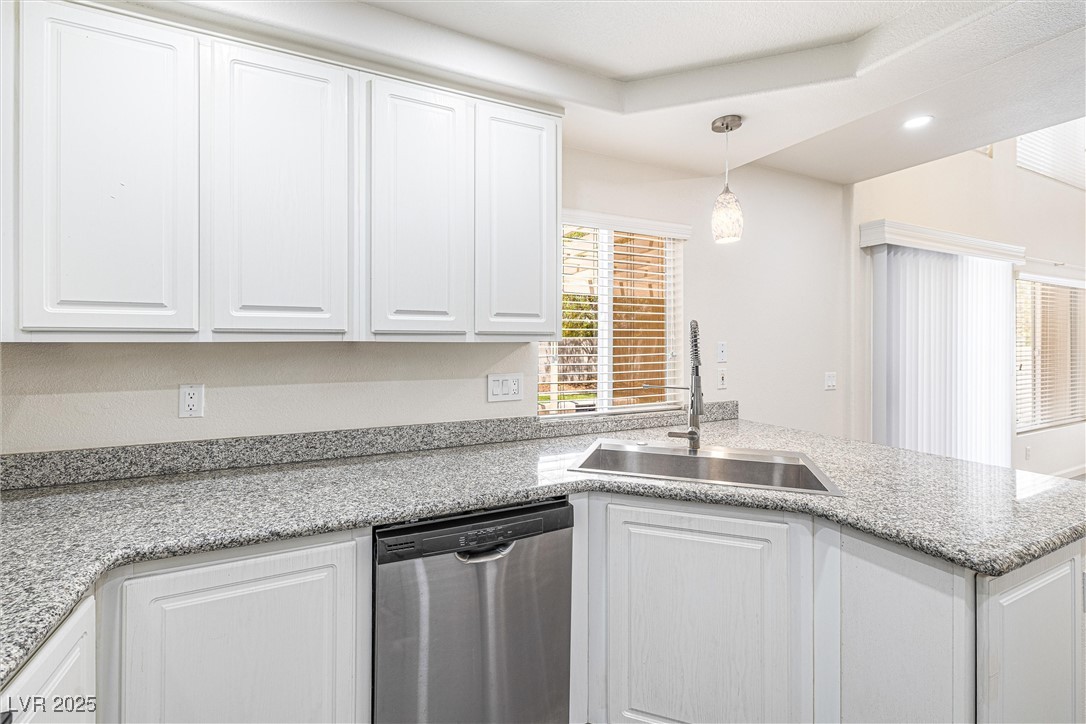 10133 Rice Paper Street Las Vegas, NV 89183 - Photo 16 of 36 Kitchen featuring NEW stainless steel dishwasher, white cabinets, a peninsula, hanging light fixtures, and recessed lighting