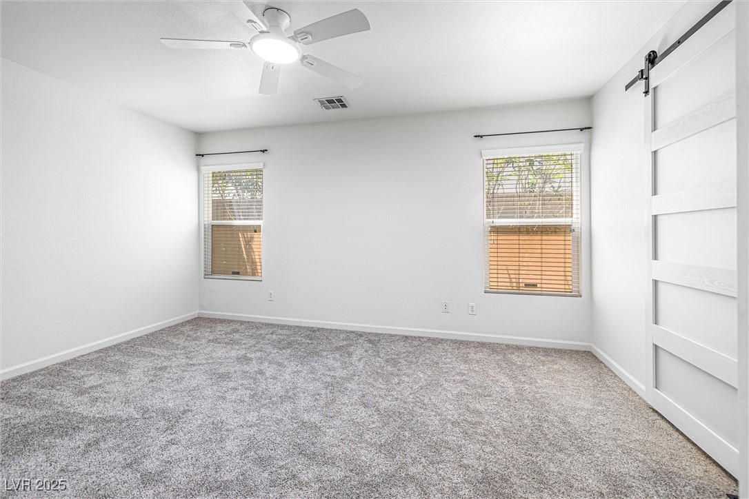 10133 Rice Paper Street Las Vegas, NV 89183 - Photo 18 of 36 Master Bedroom featuring NEW: carpet, memory foam pad, a NEW barn door, and NEW ceiling fan