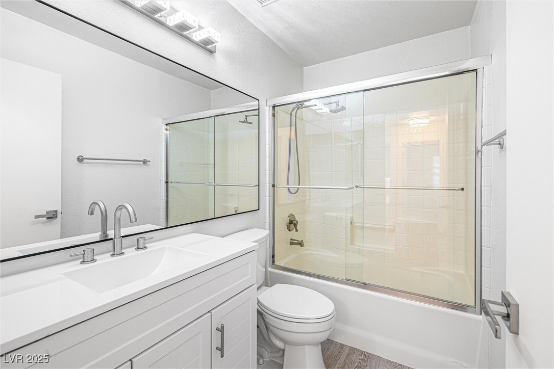 10133 Rice Paper Street Las Vegas, NV 89183 - Photo 24 of 36 Full bath upstairs featuring NEW vanity, bath / shower combo with glass door, and wood finished floors