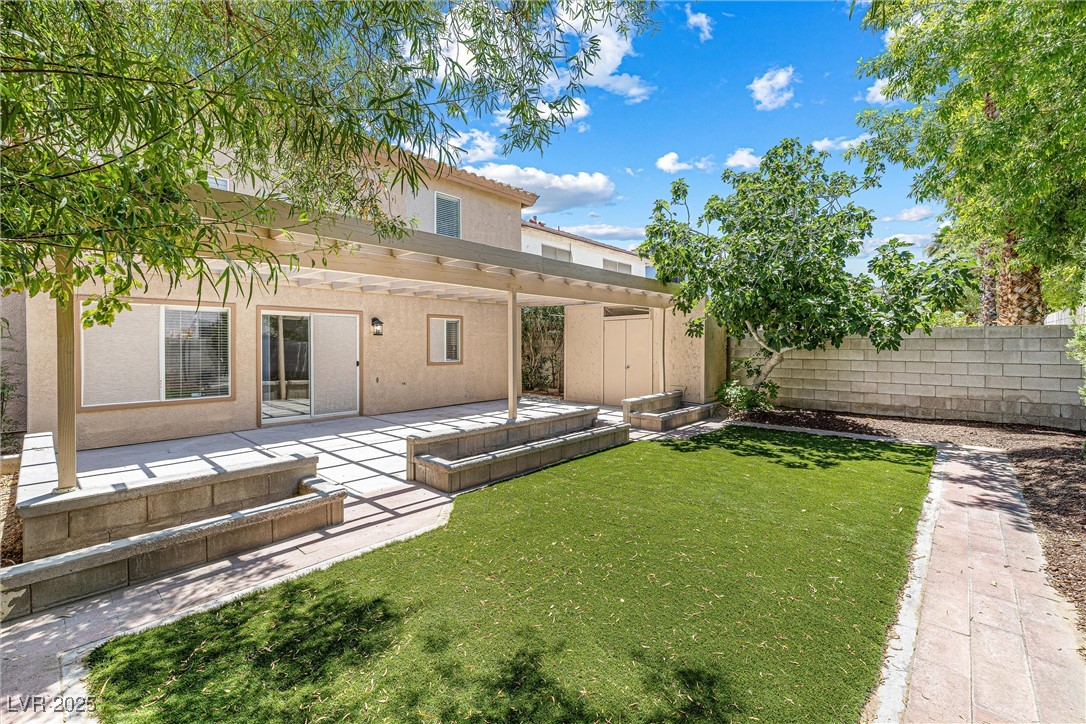 10133 Rice Paper Street Las Vegas, NV 89183 - Photo 34 of 36 Highly Upgraded Turf-Separate shed, a pergola, a fenced backyard, and a patio