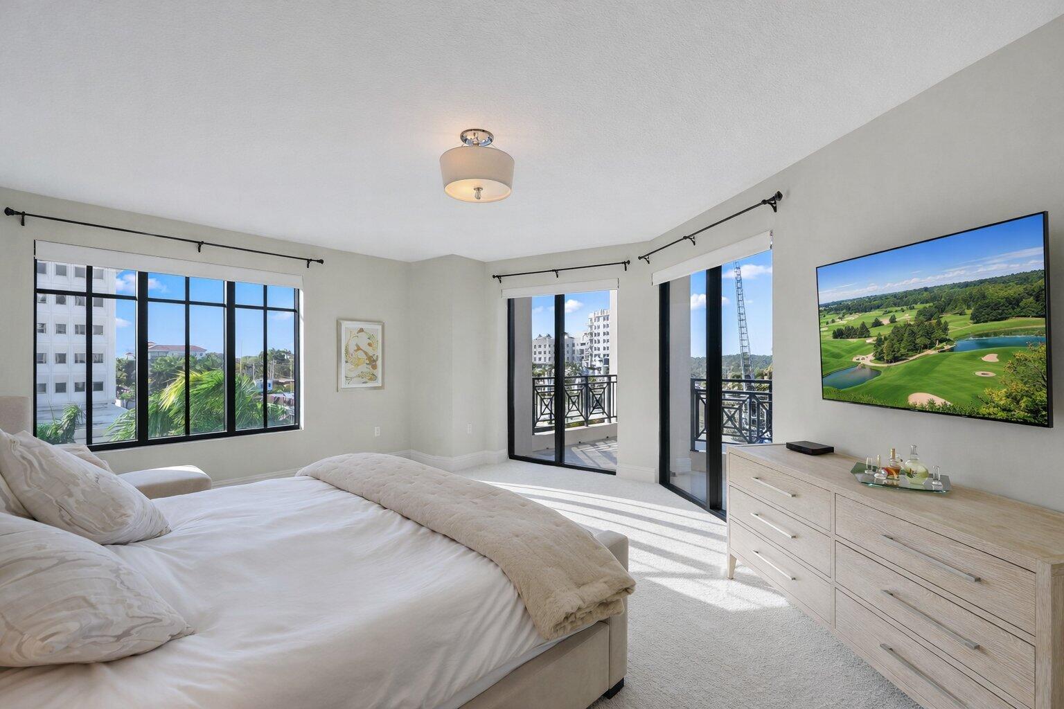 200 East Palmetto Park Road, Unit 505 Boca Raton, FL 33432 - Photo 24 of 71 a large bedroom with a large bed and a flat tv screen on dresser