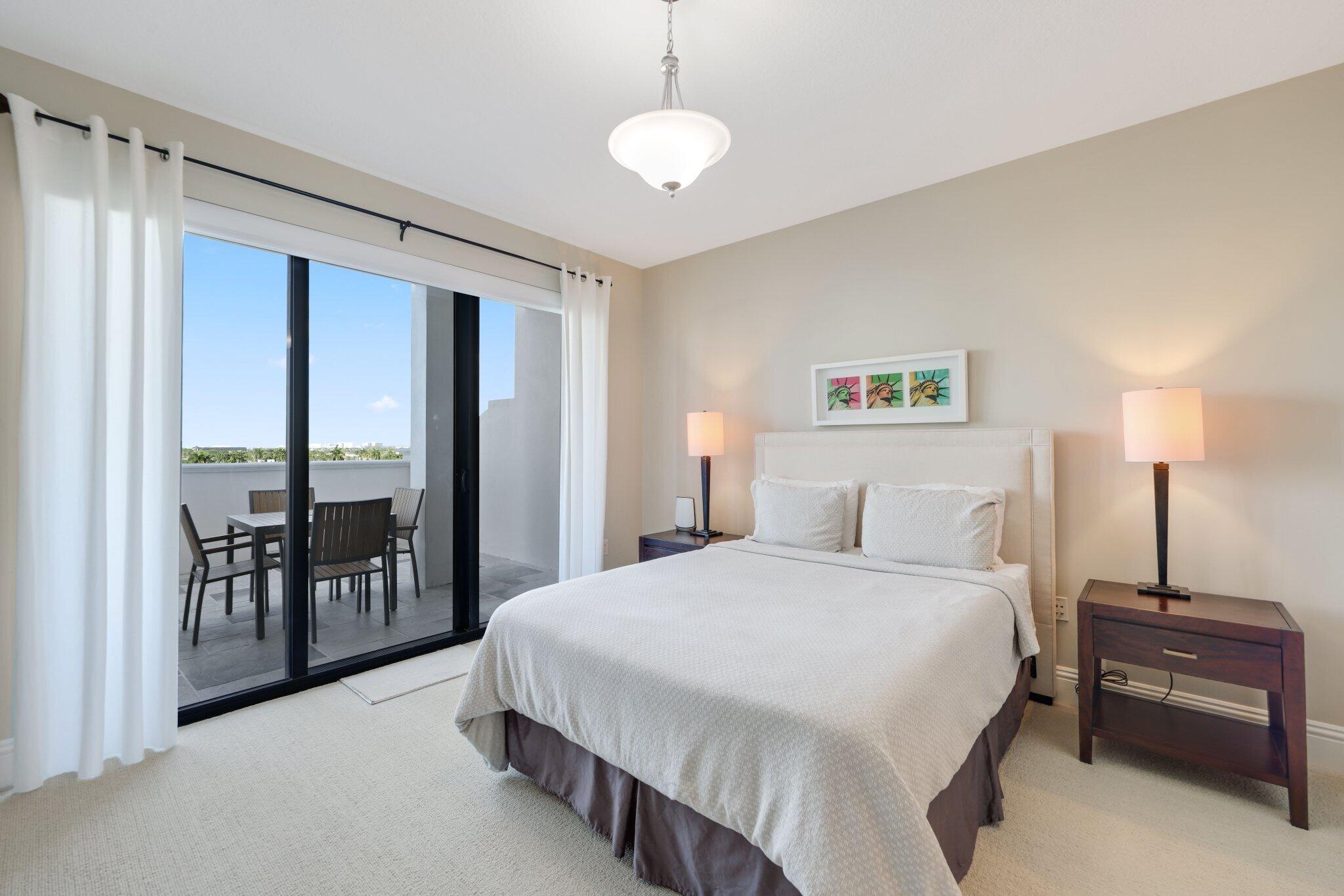 200 East Palmetto Park Road, Unit 505 Boca Raton, FL 33432 - Photo 38 of 71 a spacious bedroom with a bed and a chandelier