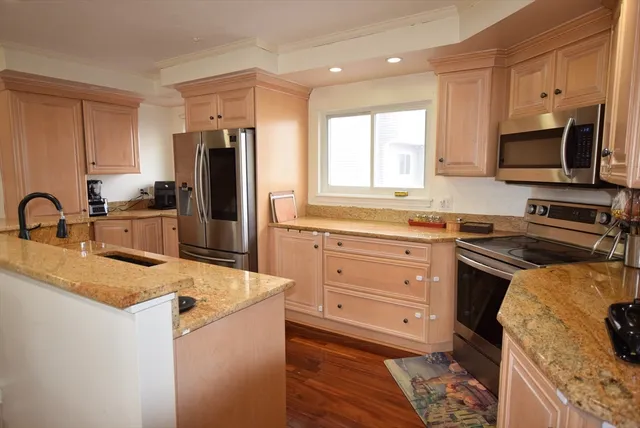 a kitchen with granite countertop a sink stove and refrigerator
