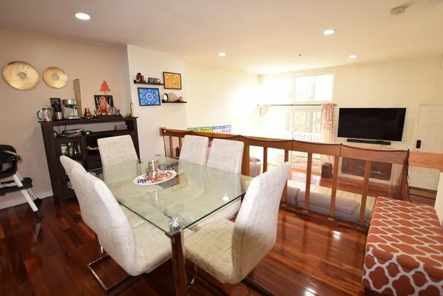 a view of a dining room with furniture a rug and wooden floor