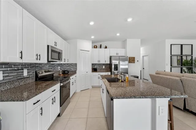 a kitchen with granite countertop stainless steel appliances and white cabinets
