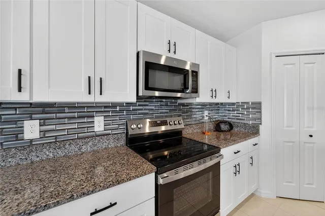 a kitchen with stainless steel appliances a refrigerator a stove a washer and dryer