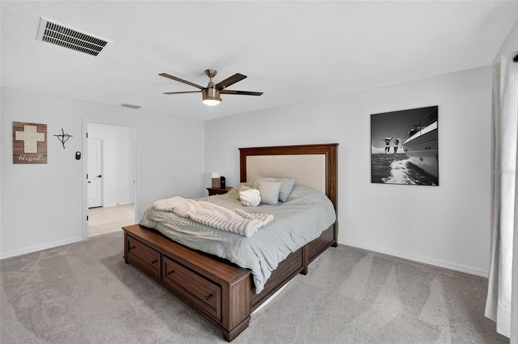 13073 Garnet Raspberry Avenue Wimauma, FL 33598 - Photo 36 of 50 a bedroom with a bed and a ceiling fan